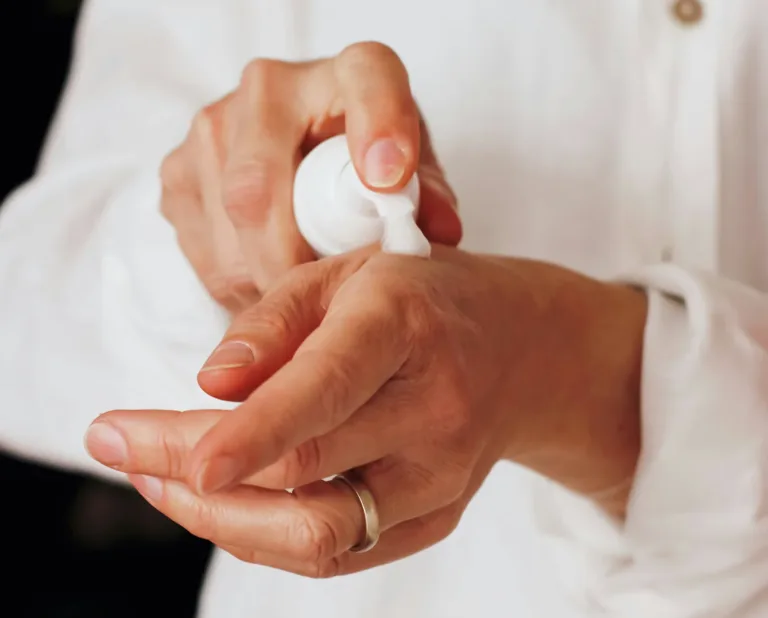 Woman applies bio-identical progesterone cream to her wrists